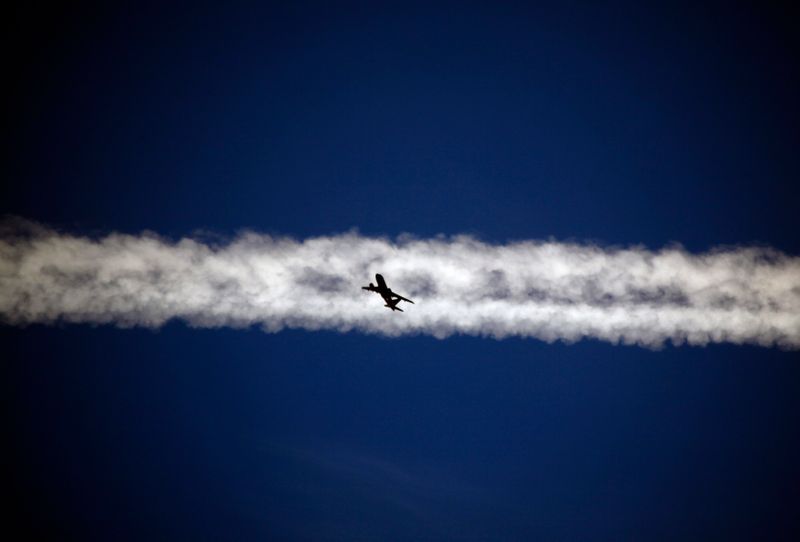 &copy; Reuters. FILE PHOTO:  An aeroplane flies underneath the jet stream of another aircraft above the Italian city of Padova