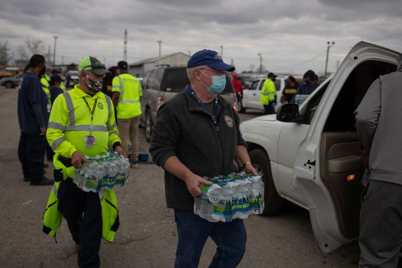 © Reuters. Volunteers give water to residents affectred by  unprecedented winter storm in Houston, Texas