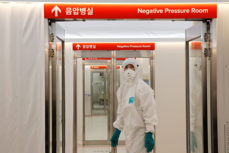 © Reuters. FILE PHOTO: A medical worker checks the doors inside the Mobile Clinic Module outside Korea Cancer Center Hospital in Seoul