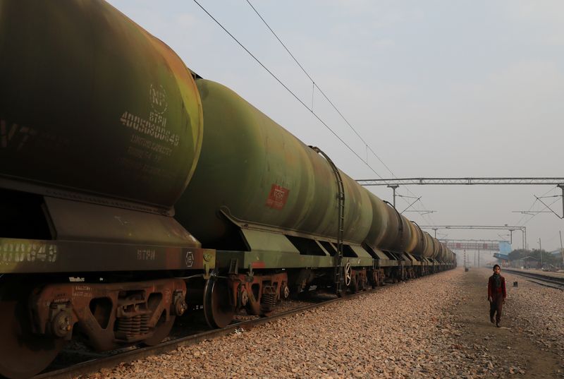 &copy; Reuters. A boy walks past an oil tanker train stationed at a railway station in Ghaziabad