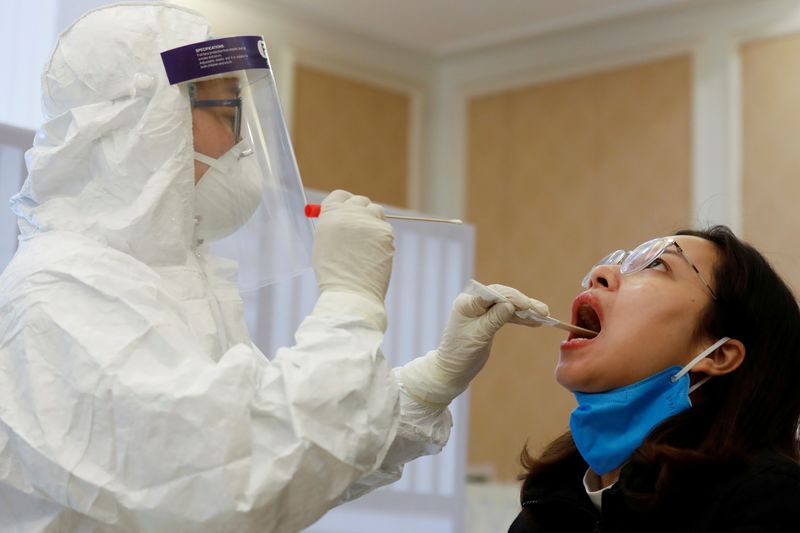 &copy; Reuters. FILE PHOTO: A health worker takes a sample for a coronavirus test in Hanoi