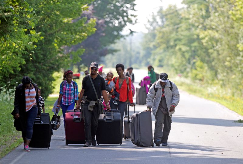 &copy; Reuters. FILE PHOTO: Three families that claimed to be from Burundi walk down Roxham Road to cross into Quebec at the US-Canada border in Champlain, New York
