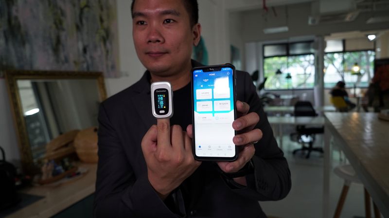 &copy; Reuters. Nervotec founder Jonathan Lau shows the comparison in vital signs readings between his company&apos;s app and a pulse oxygen monitor, in Singapore