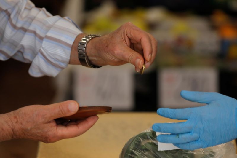 &copy; Reuters. Un comprador paga con monedas de euro en una frutería durante la epidemia de coronavirus (COVID-19), en Ronda