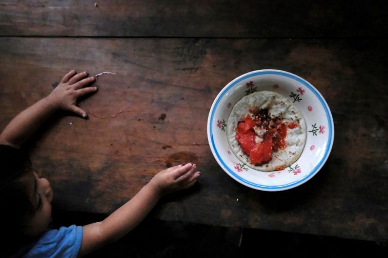 &copy; Reuters. Criança de 1 ano e 10 meses tenta alcançar prato de comida em Palmilla, na Guatemala