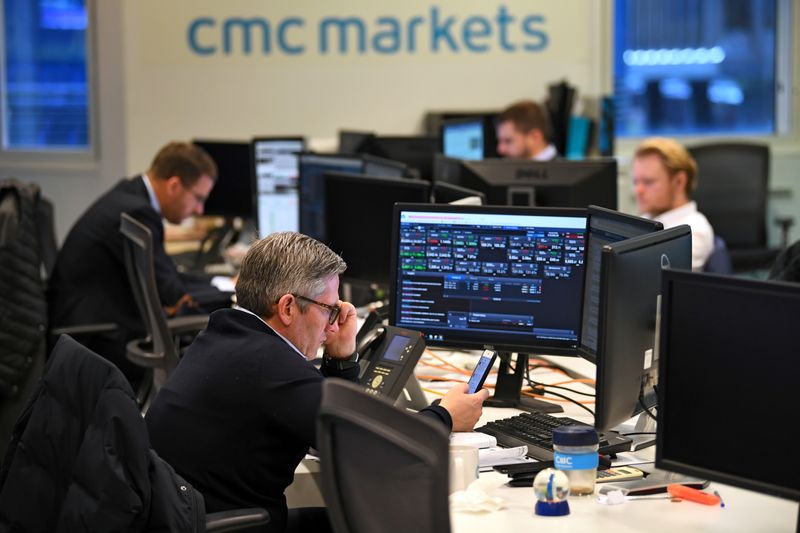 &copy; Reuters. FOTO DE ARCHIVO: Operadores trabajan en sus escritorios mientras las pantallas muestran datos del mercado en CMC Markets en Londres, Gran Bretaña.