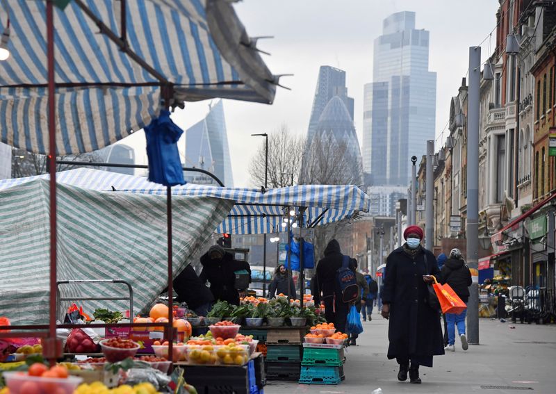 &copy; Reuters. FILE PHOTO: People shop at market stalls, with skyscrapers of the CIty of London financial district seen behind, in London
