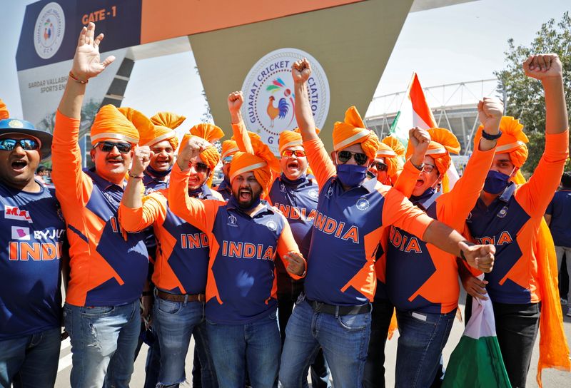 © Reuters. Fans wearing traditional headgear react as they wait to enter the newly named Narendra Modi Stadium, in Ahmedabad