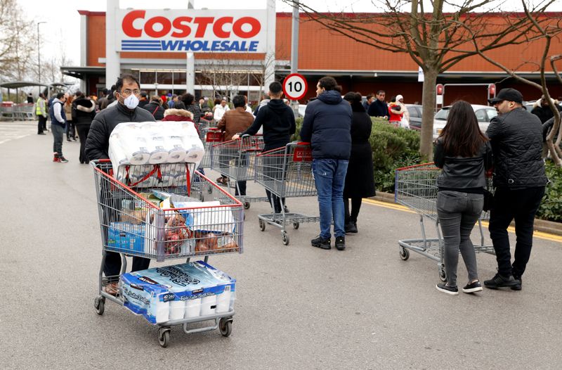 &copy; Reuters. A masked customer leaves with shopping as other customers queue to enter a Costco Wholesalers in Chingford, Britain