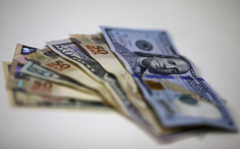 © Reuters. Notas do dólar e do real são dispostas em corretora de câmbio.