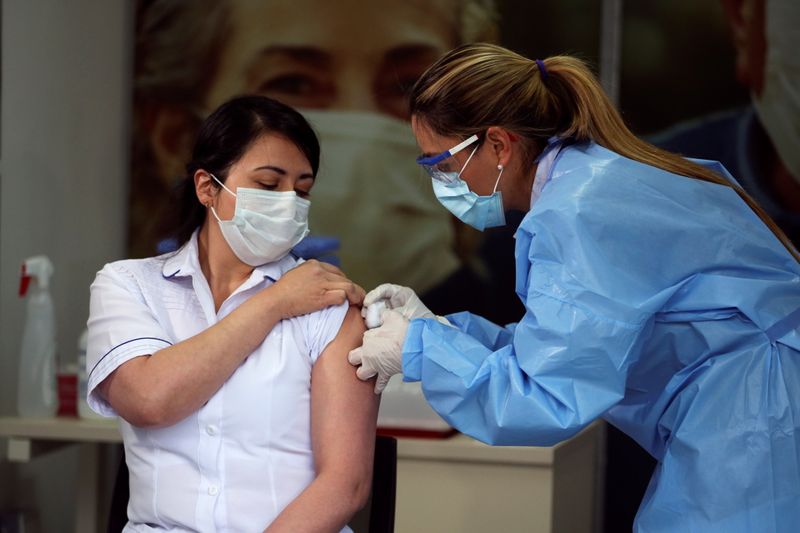 &copy; Reuters. Foto de archivo.  Claudia Benavides, enfermera de cuidados intensivos de la Clínica Colombia, recibe una inyección con una dosis de la vacuna Pfizer-BioNTech contra el COVID-19 en Bogotá