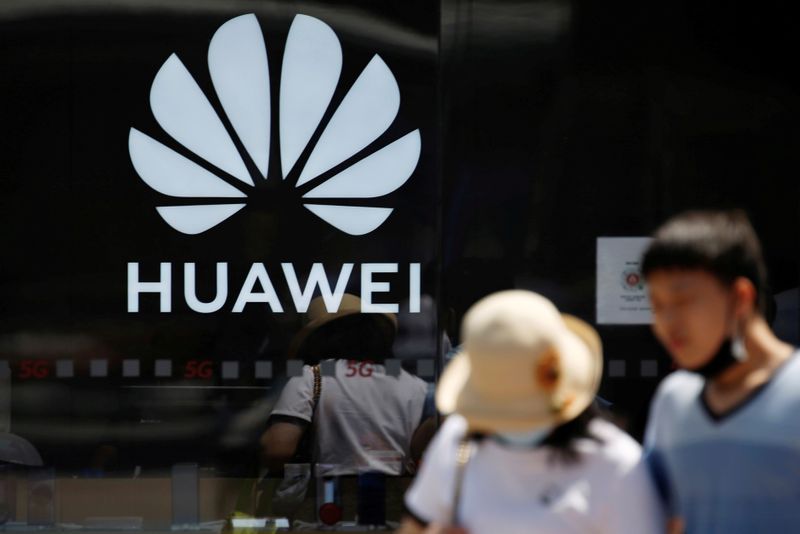 &copy; Reuters. FILE PHOTO: People walk past a Huawei store at a shopping complex in Beijing