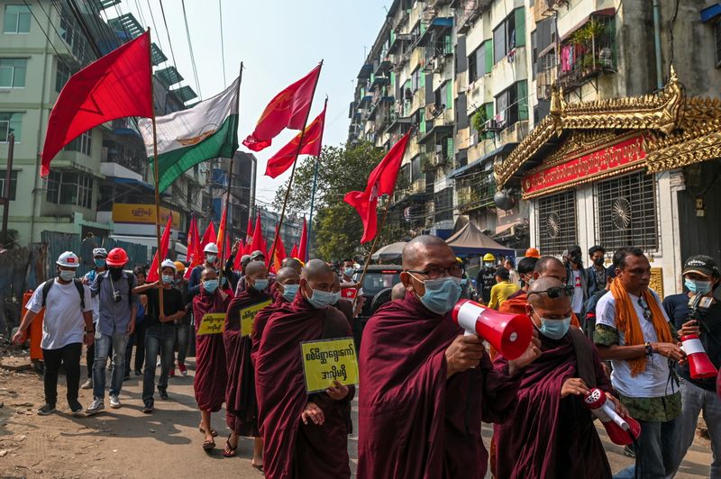 © Reuters. Buddhist monks and demonstrators rally against the military coup and to show their support to local residents after riot police officers used teargas to disperse a crowd that held a protest the night before in Yangon's Tamwe neighborhood
