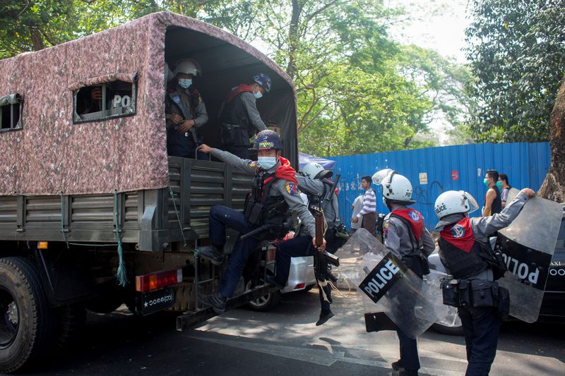 © Reuters. Riot police officers get on a police vehicle during a rally against the military coup, in Yangon