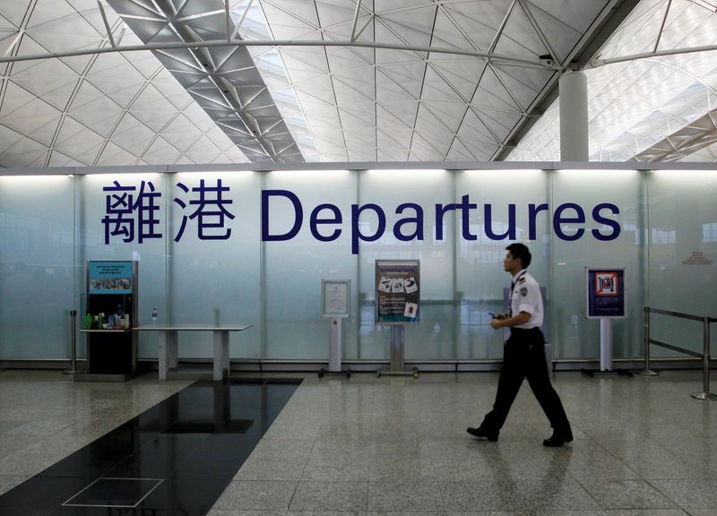 &copy; Reuters. FILE PHOTO: An airport security guard walks past a sign at the departure hall of Hong Kong Airport