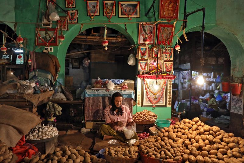 &copy; Reuters. A vendor waits for customers at his shop inside a vegetable market in Kolkata