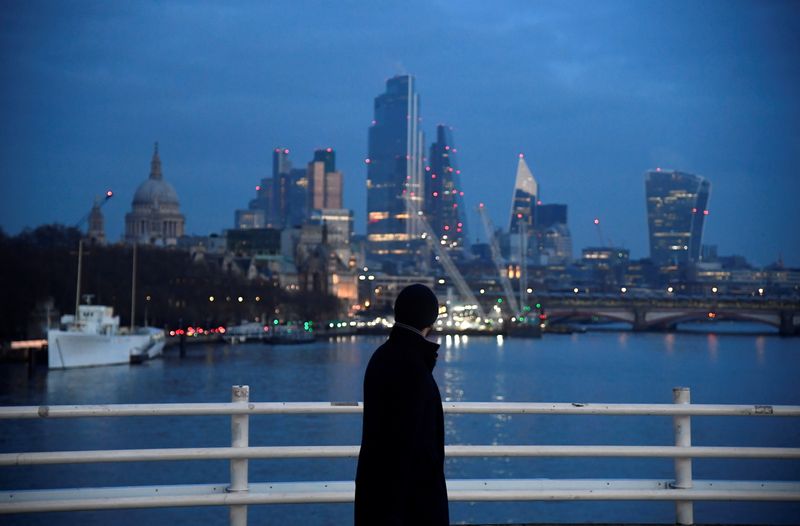&copy; Reuters. A man looks towards skyscrapers of the City of London financial district as he crosses Waterloo Bridge in London
