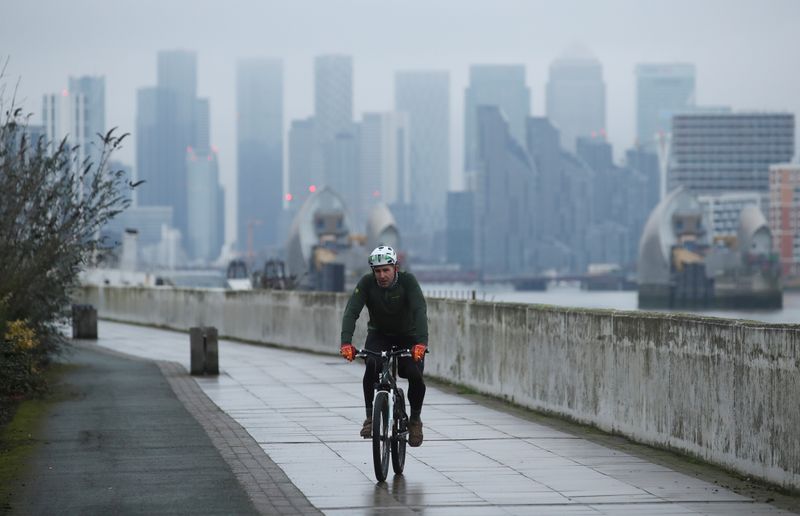 &copy; Reuters. FILE PHOTO: Buildings are seen in the Canary Wharf business district, as a man cycles along a path, amid the outbreak of the coronavirus disease (COVID-19), in London