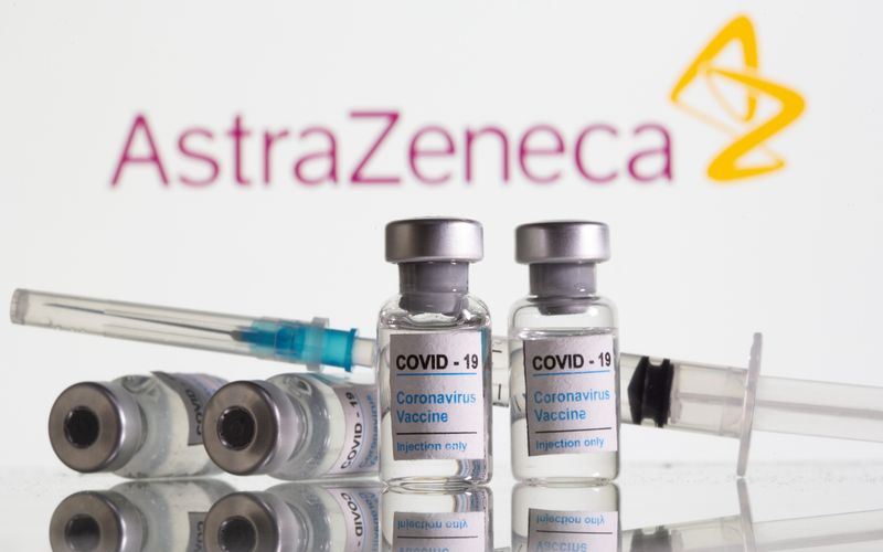 &copy; Reuters. Vials labelled &quot;COVID-19 Coronavirus Vaccine&quot; and sryinge are seen in front of displayed AstraZeneca logo in this illustration