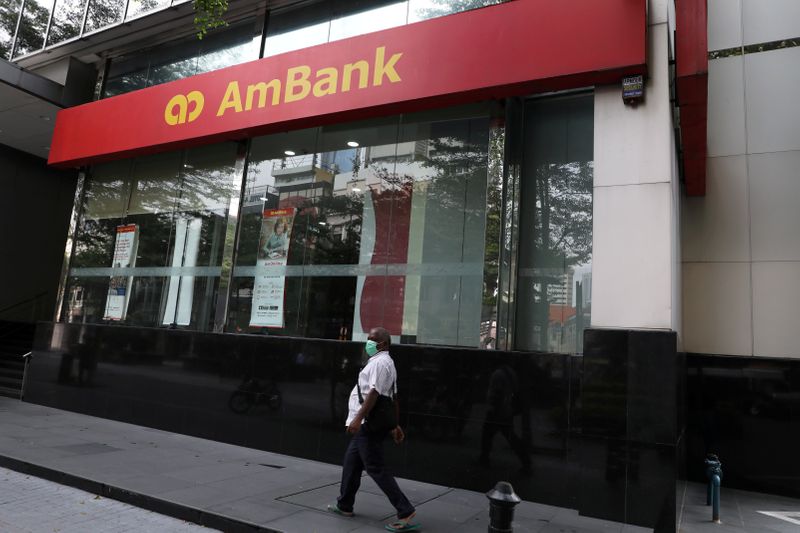 © Reuters. FILE PHOTO: A man wearing a protective mask walks past an Ambank branch, amid the coronavirus disease (COVID-19) outbreak in Kuala Lumpur