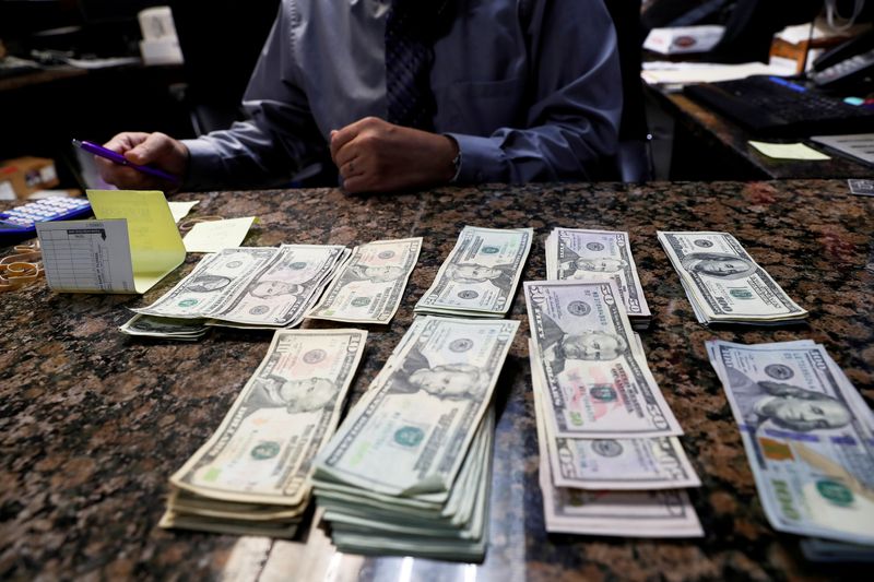 &copy; Reuters. FILE PHOTO: Carlos Gonzalez, managing partner of the Oz Ladies&apos; and Gentlemen&apos;s Nightclub, counts money ahead of the Tampa Bay area weekend NFL&apos; Super Bowl LV amid the ongoing spread of the coronavirus disease (COVID-19) at in Clearwater, F