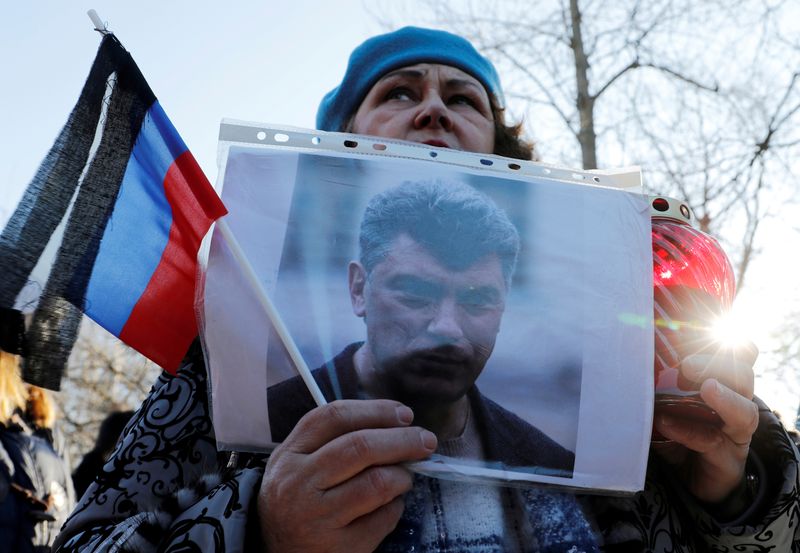 &copy; Reuters. FILE PHOTO: A woman holds a photo of Russian opposition politician Boris Nemtsov during a rally marking the 5th anniversary of his assassination, in Saint Petersburg