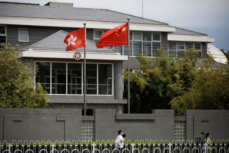 &copy; Reuters. People walk past Chinese and Hong Kong flags in Beijing