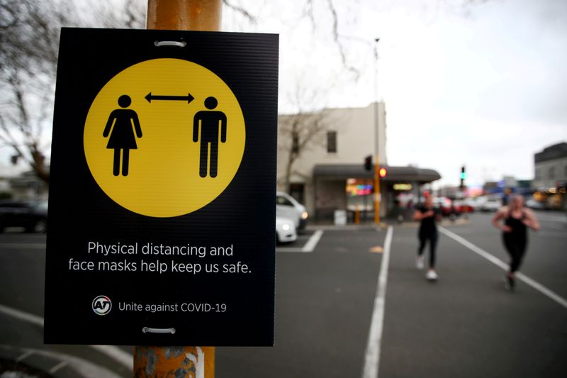 &copy; Reuters. FILE PHOTO: People jog past a social distancing sign in Auckland, New Zealand, August 31, 2020