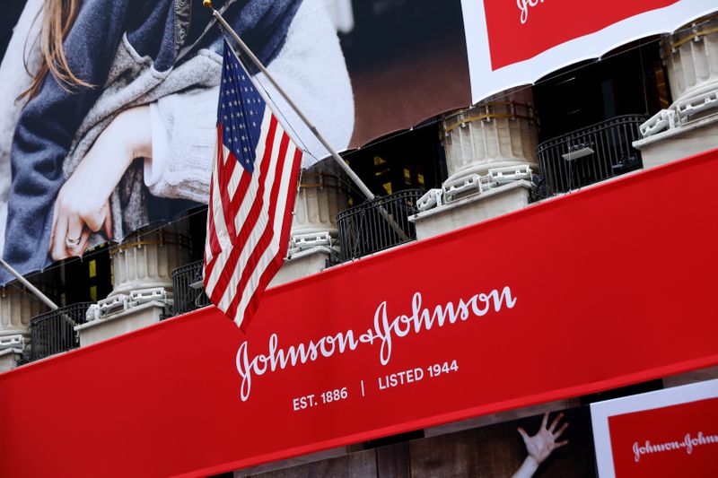 © Reuters. The U.S. flag is seen over the company logo for Johnson & Johnson to celebrate the 75th anniversary of the company's listing at the NYSE in New York
