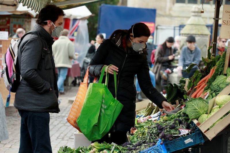 &copy; Reuters. FILE PHOTO: Shoppers wearing face masks at a market in Cambridge