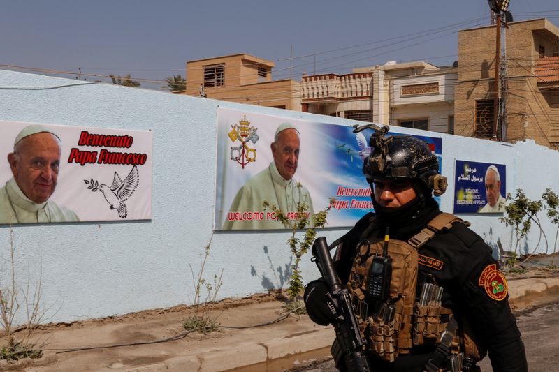 &copy; Reuters. A security man walks near posters of Pope Francis ahead of the planned visit of Pope Francis to Iraq, in Baghdad