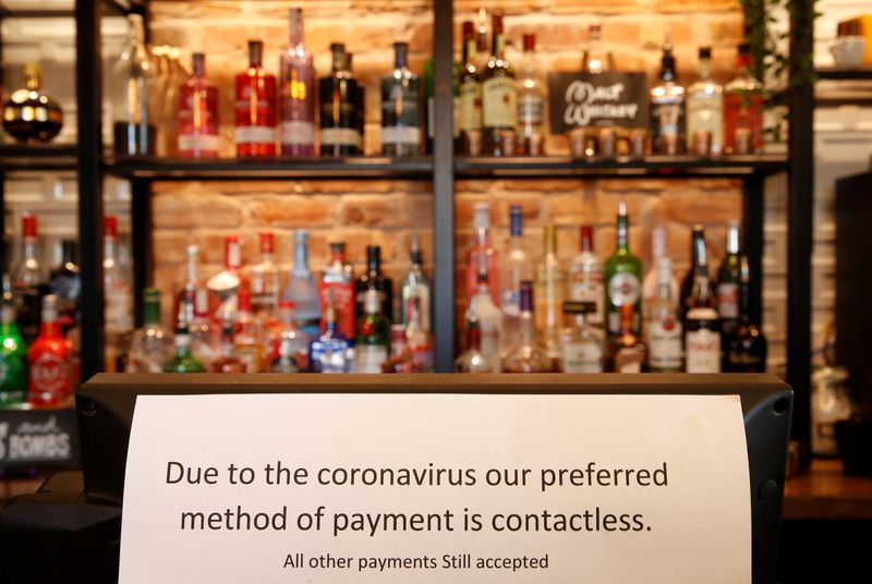 &copy; Reuters. A sign asking customers to only use contactless payment methods is seen in a pub in Liverpool, Britain