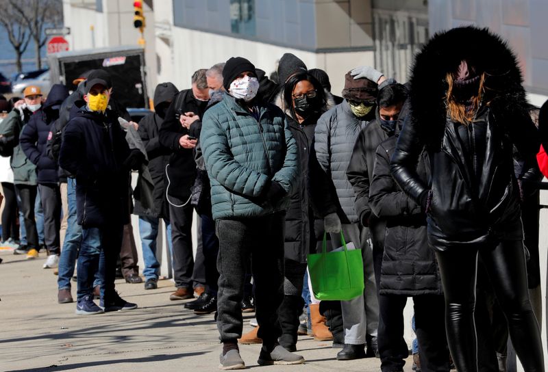 © Reuters. FILE PHOTO: People wait for COVID-19 vaccinations at mass vaccination site in Manhattan in New York