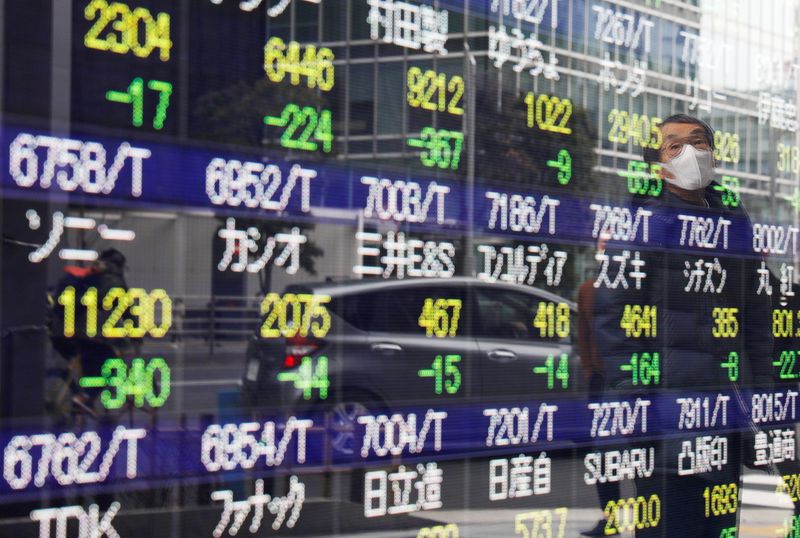 &copy; Reuters. A man is reflected on a stock quotation board in Tokyo