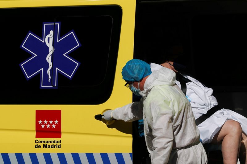 &copy; Reuters. FILE PHOTO: A healthcare worker in protective gear assists a patient into an ambulance outside the emergency unit of the Hospital Universitario La Paz during the coronavirus disease (COVID-19) outbreak in Madrid