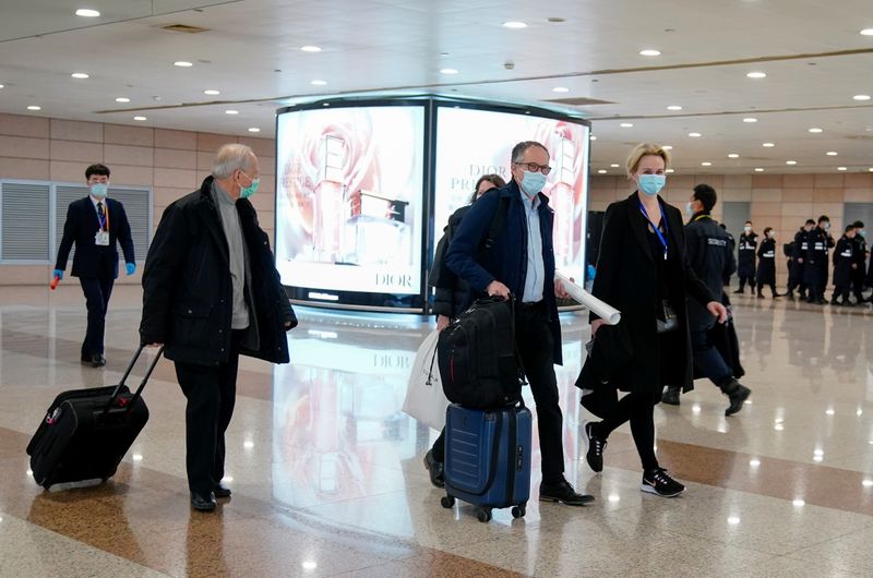 &copy; Reuters. Members of the World Health Organisation (WHO) arrive at the airport in Shanghai