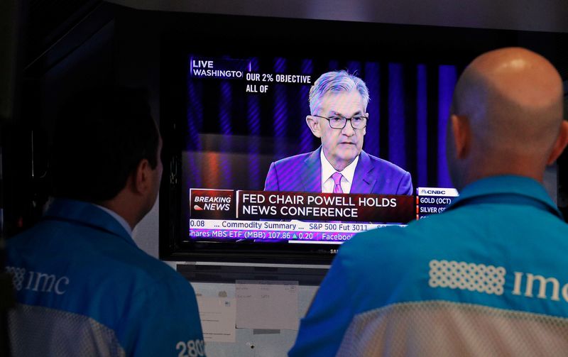© Reuters. FILE PHOTO: Traders look on as a screen shows Federal Reserve Chairman Jerome Powell's news conference after the U.S. Federal Reserve interest rates announcement on the floor of the New York Stock Exchange (NYSE) in New York