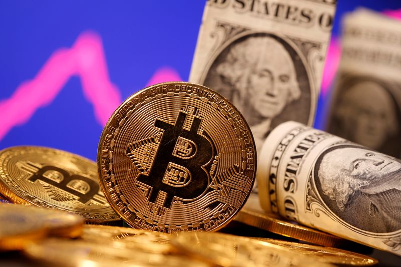 © Reuters. FILE PHOTO: A representation of virtual currency Bitcoin and U.S. One Dollar banknotes are seen in front of a stock graph in this illustration