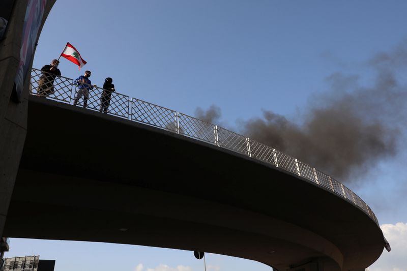&copy; Reuters. Demonstrators stand on a bridge as smoke rises from tires set on fire, during a protest in Jal el-Dib