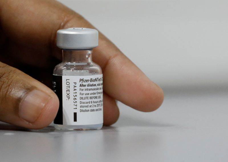 &copy; Reuters. Profissional de saúde segura frasco de vacina da Pfizer contra Covid-19 em Cingapura