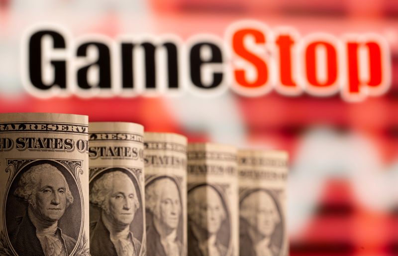 © Reuters. FILE PHOTO: U.S. one dollar banknotes are seen in front of displayed GameStop logo