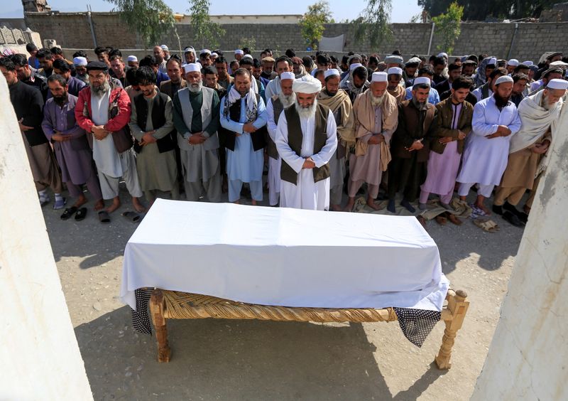 &copy; Reuters. FILE PHOTO: Afghan men pray in front of the coffin of one of three female media workers who were shot and killed by unknown gunmen, in Jalalabad