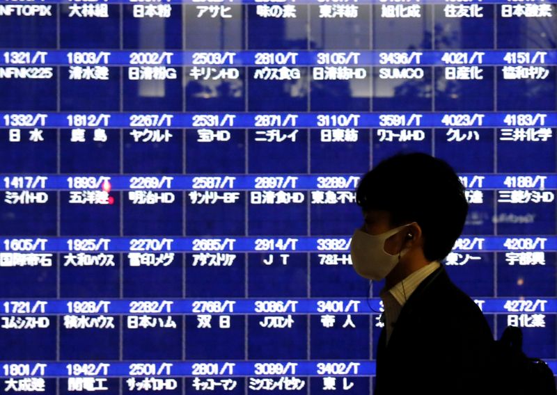 &copy; Reuters. Un passante di fronte a uno schermo alla Borsa di Tokyo