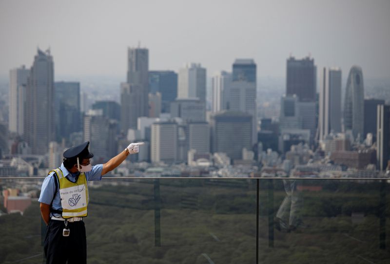 &copy; Reuters. A security personnel wearing a protective face mask is seen with Tokyo&apos;s skyscrapers in the background amid the coronavirus disease (COVID-19) outbreak in Tokyo