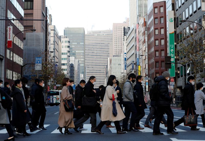 &copy; Reuters. FOTO DE ARCHIVO: Peatones con mascarillas en un distrito comercial en Tokio, Japón