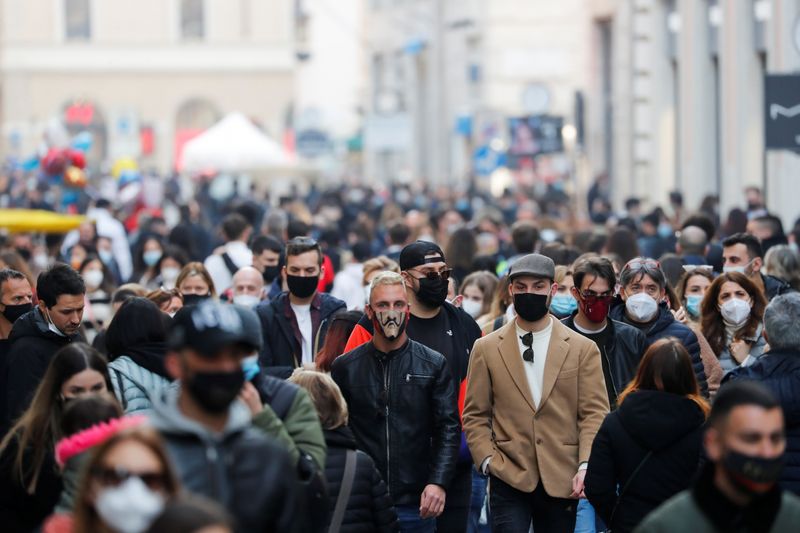 &copy; Reuters. Persone con indosso la mascherina passeggiano in Via del Corso a Roma