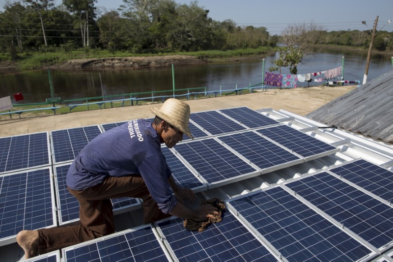 &copy; Reuters. Homem checa painel de energia solar instalado em Vila Nova do Amanã (AM)