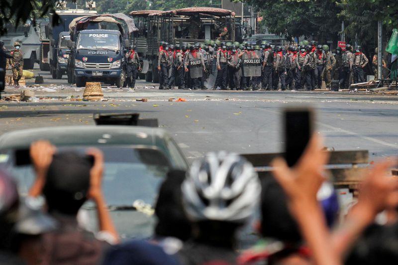 © Reuters. FILE PHOTO: Police stand on a road during an anti-coup protest in Mandalay