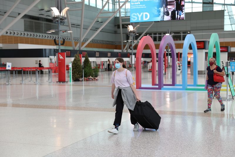 &copy; Reuters. People wearing masks walk through Sydney Airport in the wake of a COVID-19 outbreak in Sydney