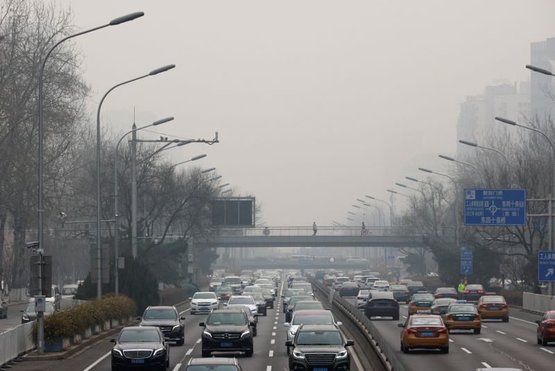 &copy; Reuters. Cars drive in the city centre during a polluted day in Beijing